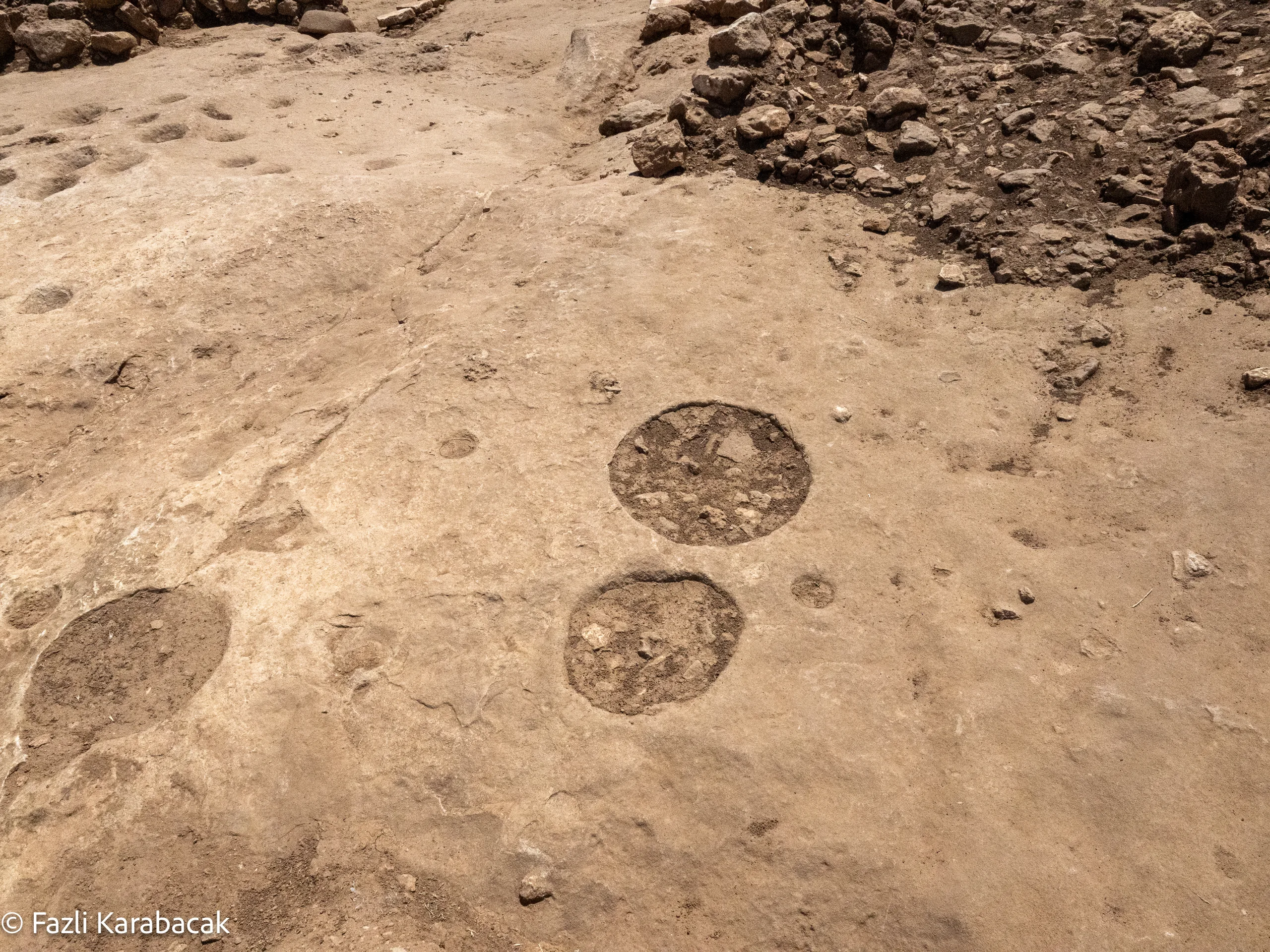 Circular burial pits carved into the bedrock floor at Karahantepe, where human skull remains were ritually deposited during the Neolithic period. © Fazli Karabacak